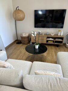 Intérieur tendance avec un mélange de matériaux naturels (bois, marbre) et de couleurs neutres (blanc, gris). La décoration épurée crée une atmosphère apaisante